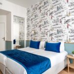 Chambre Twin avec deux lits et une couverture bleue à l’hôtel Acadia