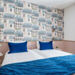 Chambre Twin avec deux lits et une couverture bleue à l’hôtel Acadia