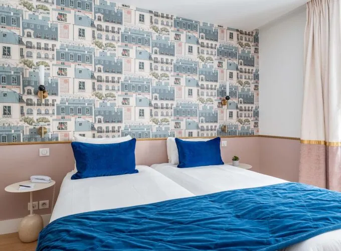 Chambre Twin avec deux lits et une couverture bleue à l’hôtel Acadia