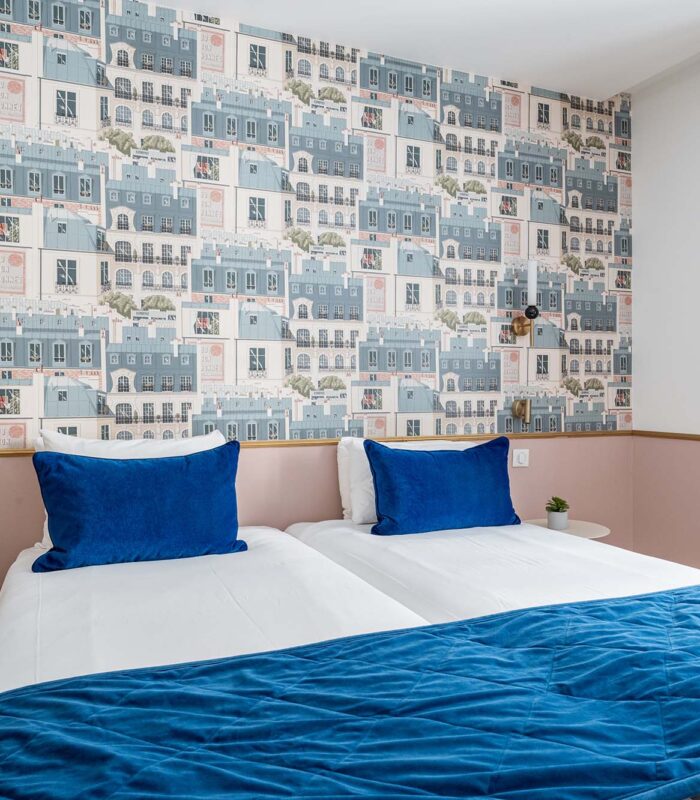 Chambre Twin avec deux lits et une couverture bleue à l’hôtel Acadia