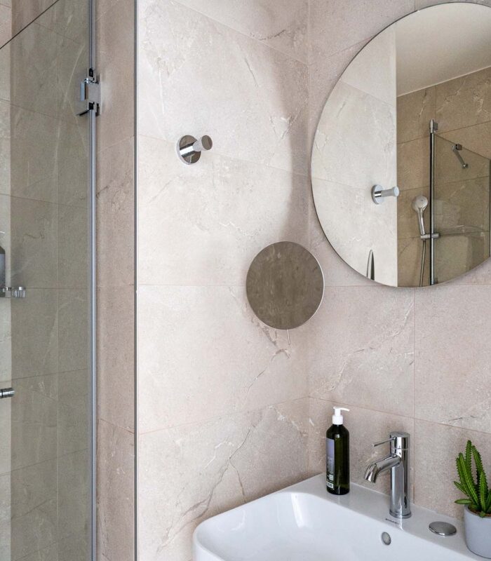 Chambre Twin avec salle de bain comprenant un lavabo et un miroir rond à l’hôtel Acadia