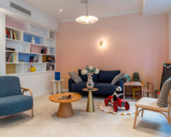 Hall d'accueil de l'hôtel 3 étoiles Acadia à Paris avec des couleurs élégantes et un espace pour enfants.