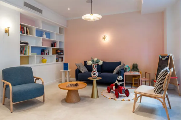 Hall d'accueil de l'hôtel 3 étoiles Acadia à Paris avec des couleurs élégantes et un espace pour enfants.