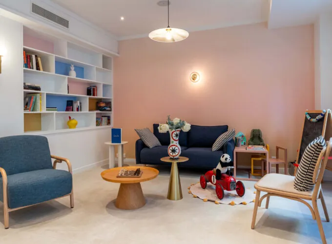 Hall d'accueil de l'hôtel 3 étoiles Acadia à Paris avec des couleurs élégantes et un espace pour enfants.