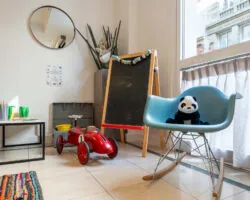 Hall d'accueil de l'hôtel 3 étoiles Acadia à Paris avec des couleurs élégantes et un espace pour enfants.
