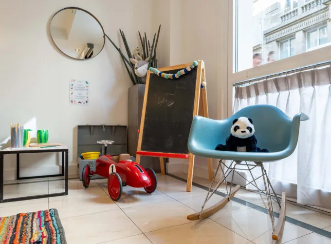 Hall d'accueil de l'hôtel 3 étoiles Acadia à Paris avec des couleurs élégantes et un espace pour enfants.