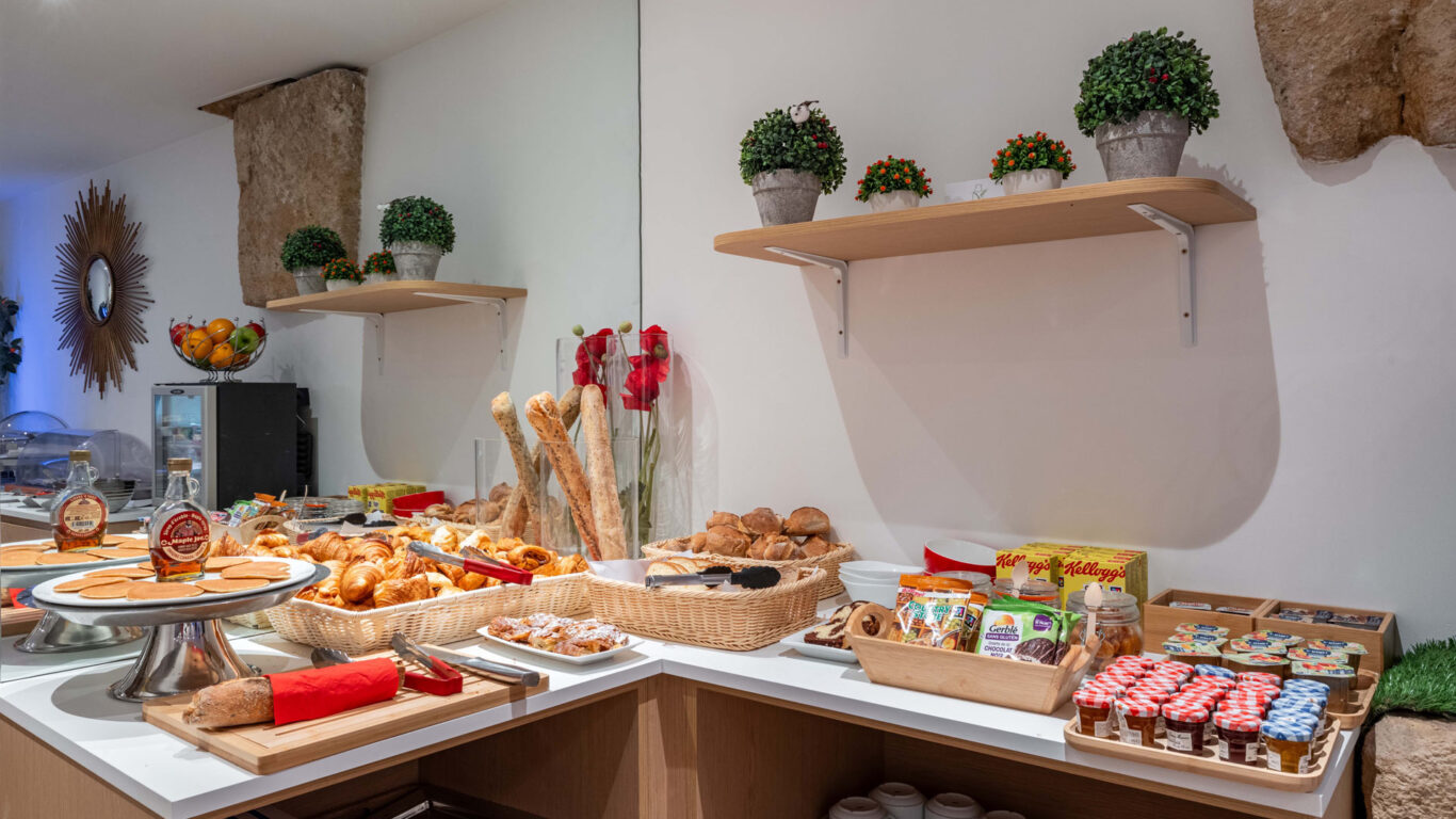 Petit-déjeuner buffet varié à l'hôtel Acadia à Paris avec viennoiseries, pains, fromages, charcuterie, yaourts, fruits et céréales.