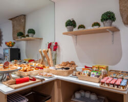 Petit-déjeuner buffet varié à l'hôtel Acadia à Paris avec viennoiseries, pains, fromages, charcuterie, yaourts, fruits et céréales.