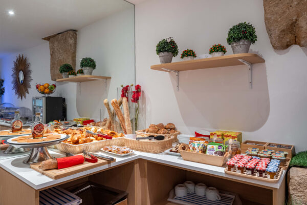 Petit-déjeuner buffet varié à l'hôtel Acadia à Paris avec viennoiseries, pains, fromages, charcuterie, yaourts, fruits et céréales.