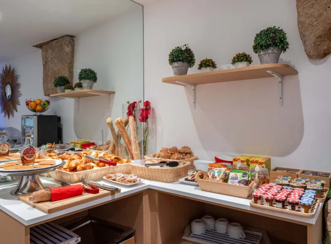 Petit-déjeuner buffet varié à l'hôtel Acadia à Paris avec viennoiseries, pains, fromages, charcuterie, yaourts, fruits et céréales.