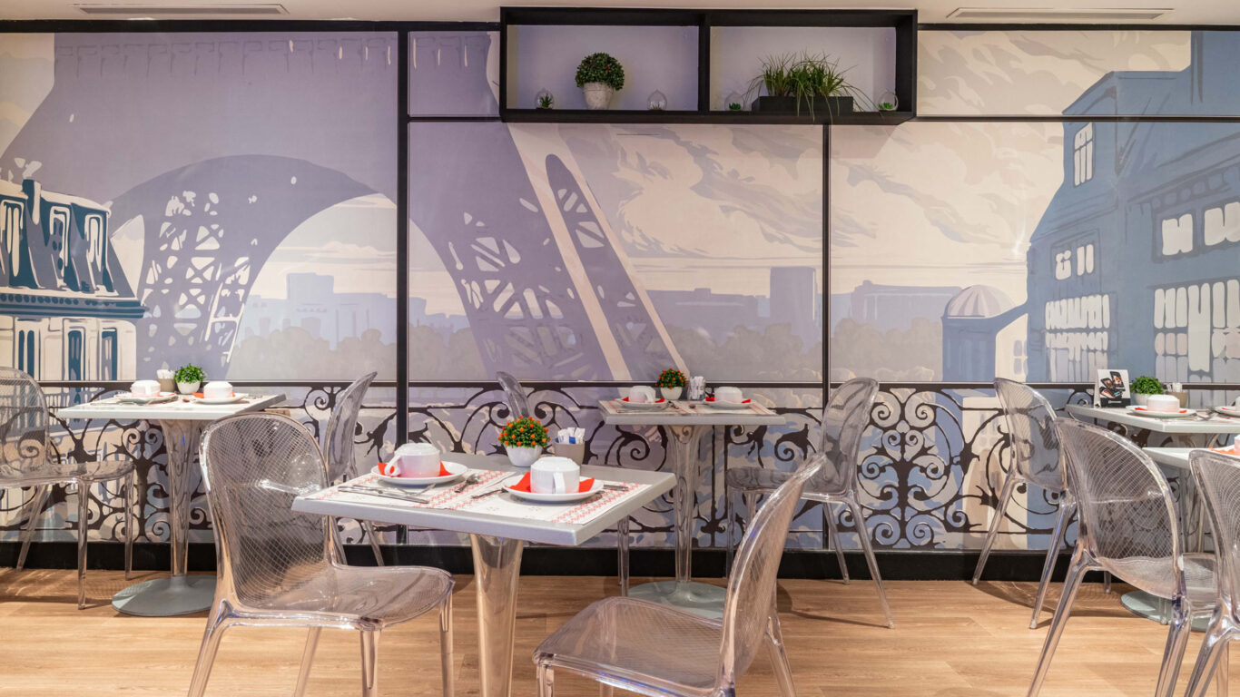 Salle de petit-déjeuner de l'hôtel Acadia à Paris avec buffet varié et ambiance chaleureuse et accueillante.