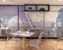 Salle de petit-déjeuner de l'hôtel Acadia à Paris avec buffet varié et ambiance chaleureuse et accueillante.