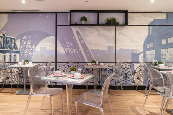 Salle de petit-déjeuner de l'hôtel Acadia à Paris avec buffet varié et ambiance chaleureuse et accueillante.
