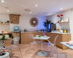 Salle de petit-déjeuner de l'hôtel Acadia à Paris avec buffet varié et ambiance chaleureuse et accueillante.