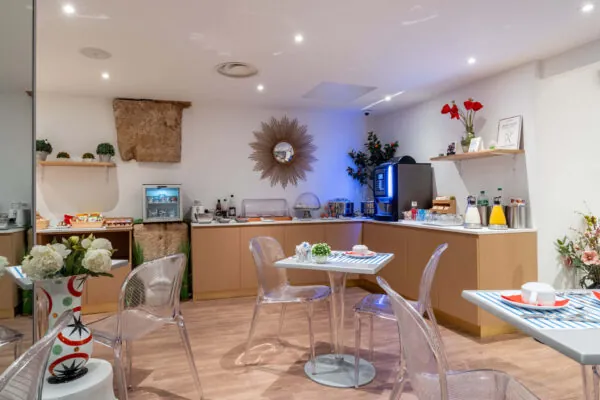Salle de petit-déjeuner de l'hôtel Acadia à Paris avec buffet varié et ambiance chaleureuse et accueillante.
