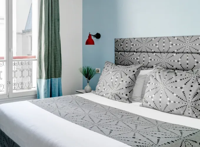 Vue du lit de la chambre double à l’hôtel Astoria, Paris