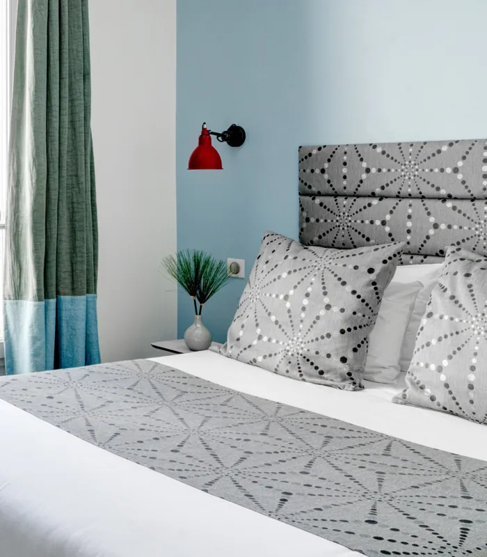 Vue du lit de la chambre double à l’hôtel Astoria, Paris