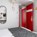 Chambre Familiale avec une porte rouge et un miroir à l’hôtel Astoria