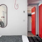 Chambre Familiale avec un lit et une porte rouge à l’hôtel Astoria