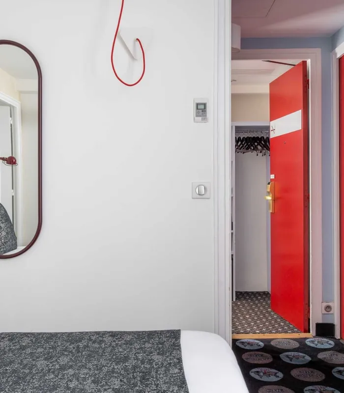 Chambre Familiale avec un lit et une porte rouge à l’hôtel Astoria