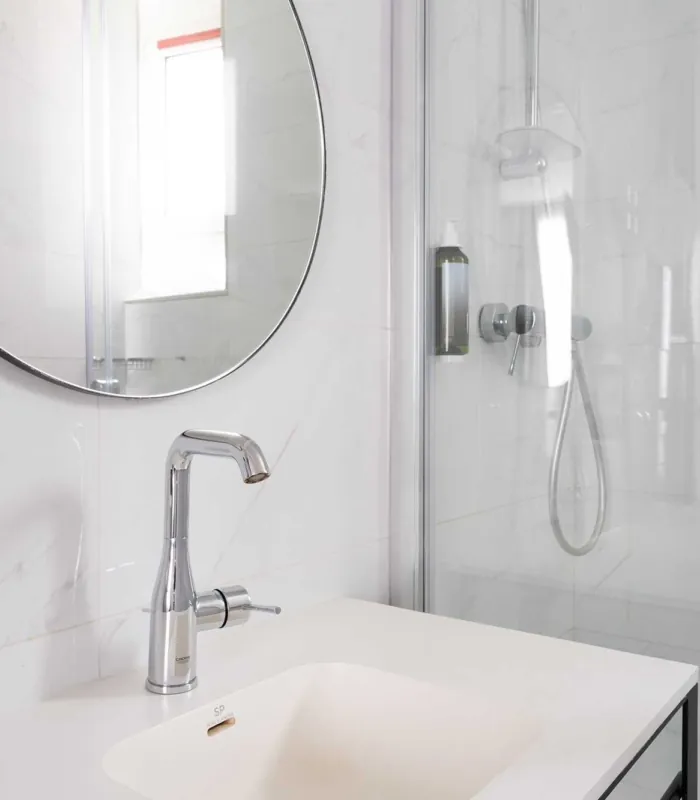Salle de bain de la Chambre Familiale avec un lavabo et un miroir rond à l’hôtel Astoria