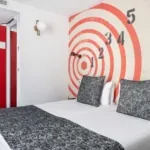 Chambre Familiale avec un lit et une horloge au mur à l’hôtel Astoria