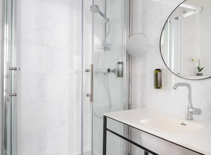 Salle de bain de la Chambre Familiale avec un lavabo et une cabine de douche à l’hôtel Astoria