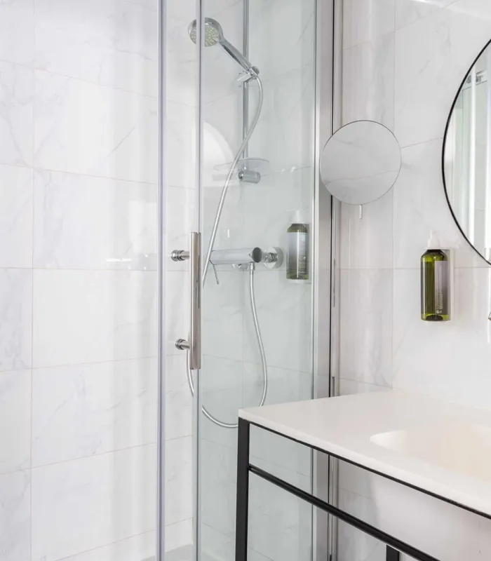 Salle de bain de la Chambre Familiale avec un lavabo et une cabine de douche à l’hôtel Astoria