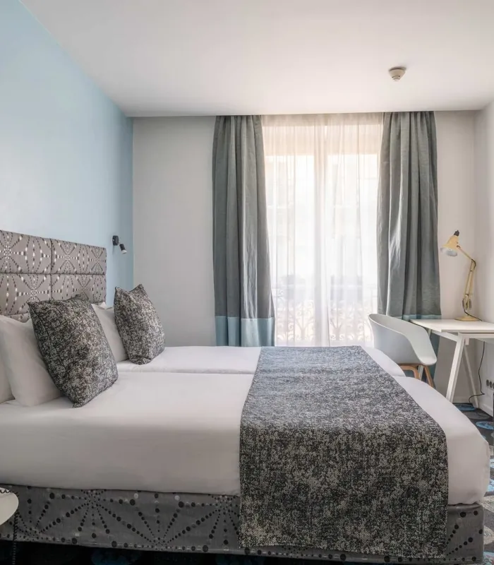 Chambre Familiale Supérieure avec deux lits et un bureau à l’hôtel Astoria