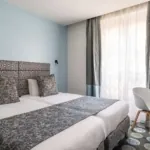 Chambre Familiale Supérieure avec un lit et un bureau à l’hôtel Astoria