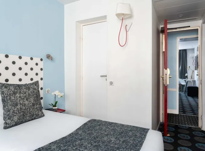Chambre Familiale Supérieure avec un lit et une lampe murale à l’hôtel Astoria