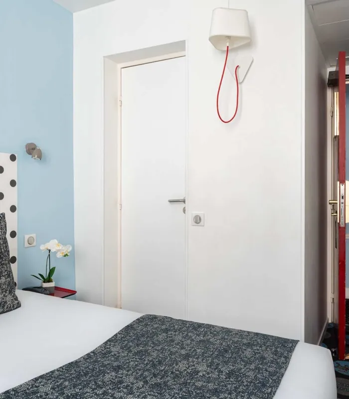 Chambre Familiale Supérieure avec un lit et une lampe murale à l’hôtel Astoria