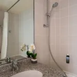 Salle de bain de la Chambre Familiale Supérieure avec un lavabo, des toilettes et une douche à l’hôtel Astoria