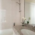 Salle de bain de la Chambre Familiale Supérieure avec un lavabo et un miroir à l’hôtel Astoria