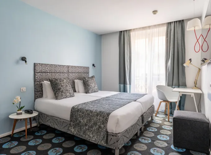 Chambre Privilège avec un lit et un bureau à l’hôtel Astoria