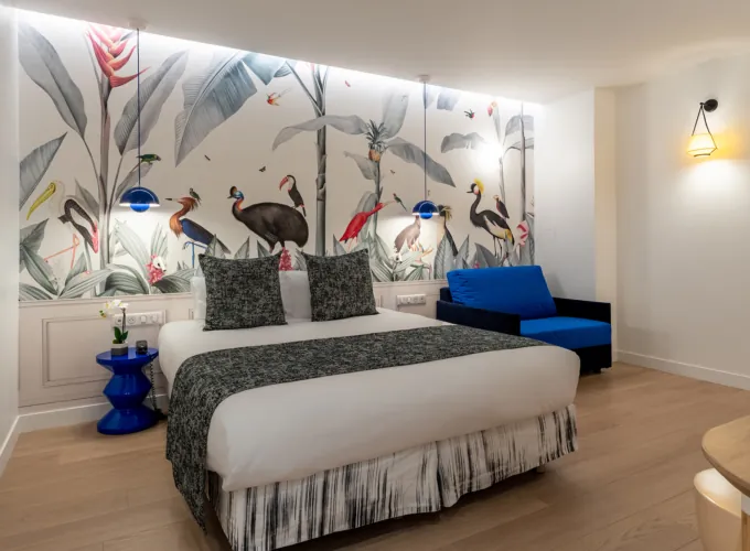 Chambre Quadruple avec un lit et une chaise bleue à l’hôtel Astoria