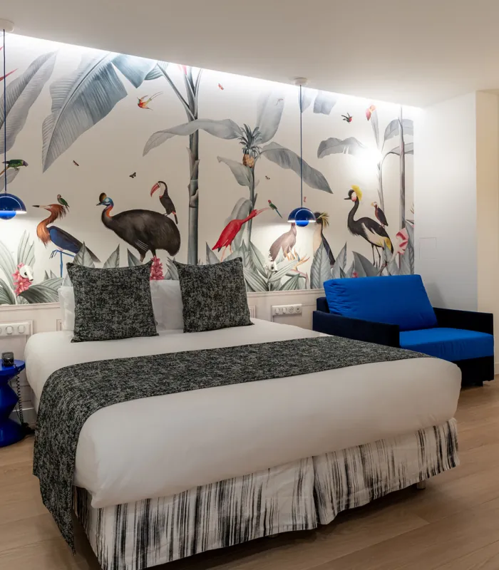 Chambre Quadruple avec un lit et une chaise bleue à l’hôtel Astoria