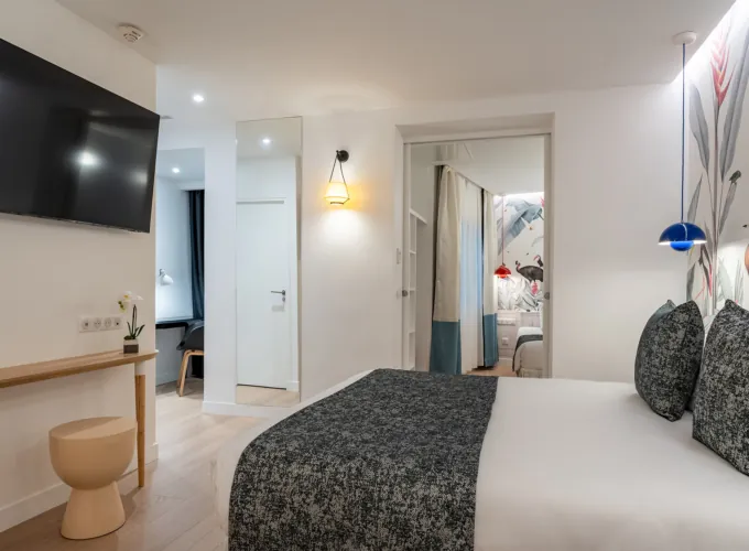 Chambre Quadruple avec un grand lit et une télévision à écran plat à l’hôtel Astoria
