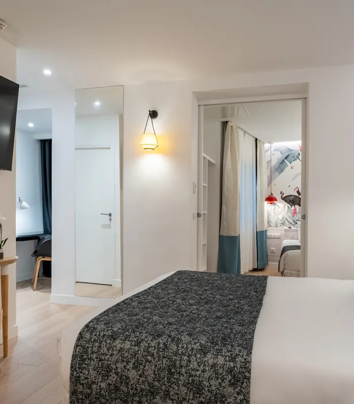 Chambre Quadruple avec un grand lit et une télévision à écran plat à l’hôtel Astoria