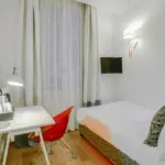 Chambre Single, petite chambre avec un lit simple et un bureau à l’hôtel Astoria