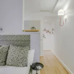 Chambre Single avec un lit et une lampe murale à l’hôtel Astoria