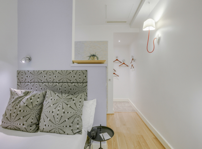 Chambre Single avec un lit et une lampe murale à l’hôtel Astoria