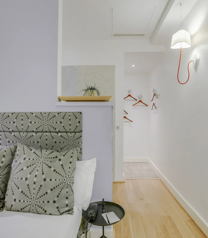 Chambre Single avec un lit et une lampe murale à l’hôtel Astoria