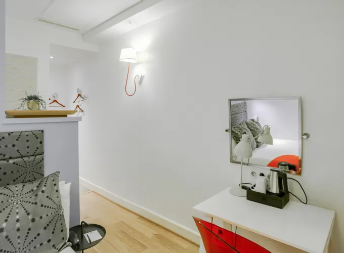 Chambre Single avec un miroir et un petit bureau à l’hôtel Astoria