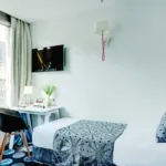 Chambre Triple avec un lit simple et un bureau à l’hôtel Astoria