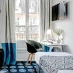 Chambre Triple avec un bureau et une télévision à écran plat à l’hôtel Astoria