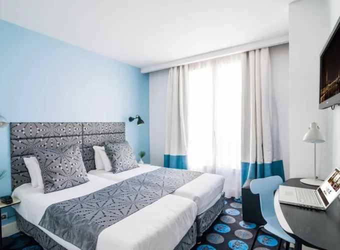 Chambre Twin avec deux lits et un bureau à l’hôtel Astoria