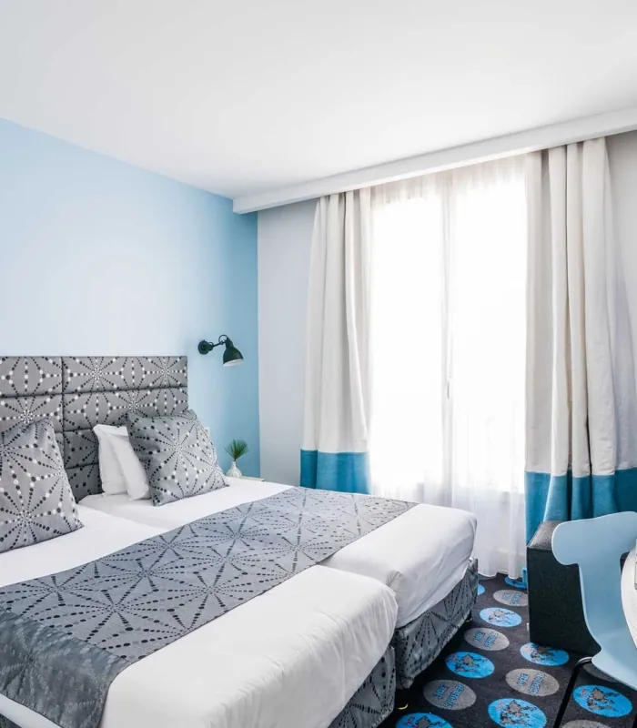 Chambre Twin avec deux lits et un bureau à l’hôtel Astoria