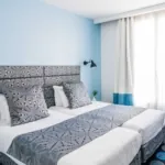 Chambre Twin avec deux lits et une fenêtre à l’hôtel Astoria