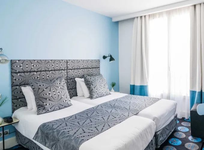 Chambre Twin avec deux lits et une fenêtre à l’hôtel Astoria